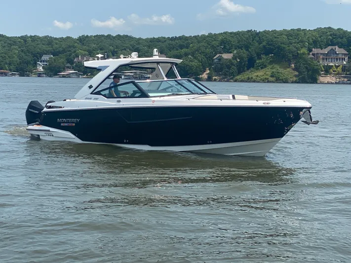  Yacht Photos Pics 2022 Monterey 385 Super Sport boat cruising on a lake with scenic background.