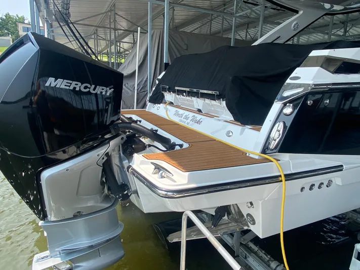  Yacht Photos Pics 2022 Monterey 385 Super Sport boat with Mercury engine, docked under a canopy.