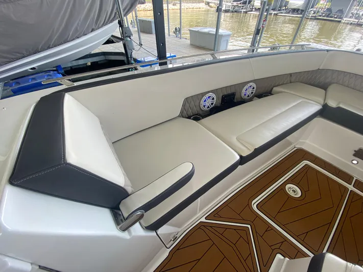  Yacht Photos Pics 2022 Monterey 385 Super Sport boat interior with cushioned seating and wood-patterned flooring.
