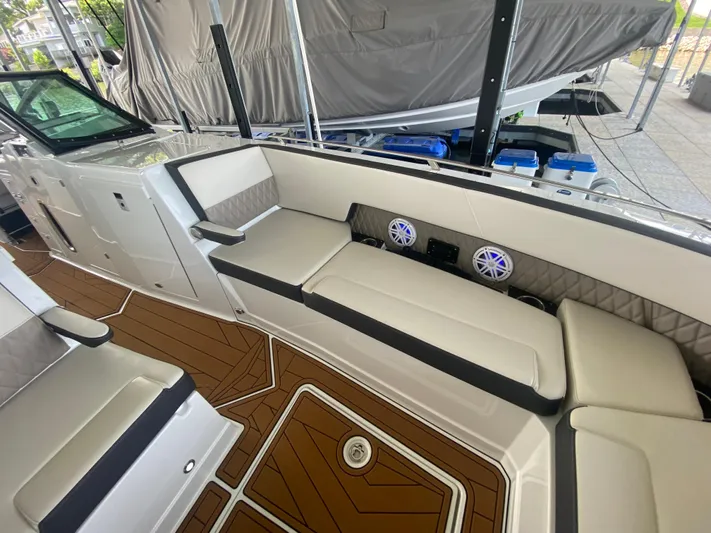  Yacht Photos Pics 2022 Monterey 385 Super Sport boat interior with cushioned seating and wood-patterned flooring.