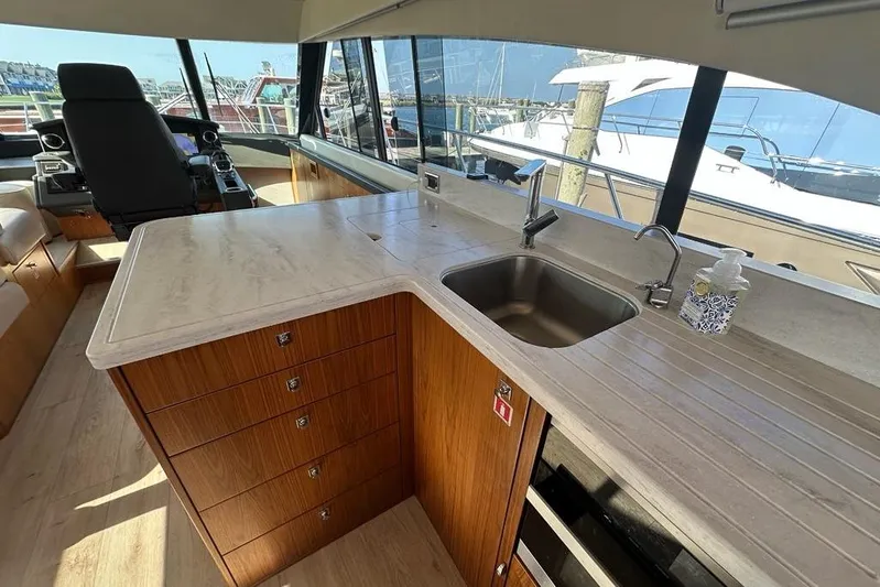 Happy Ours Yacht Photos Pics Interior of 2019 Riviera 5400 Sport Yacht with modern kitchen and helm.