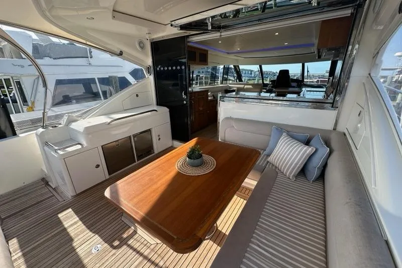 Happy Ours Yacht Photos Pics Luxurious interior of 2019 Riviera 5400 Sport Yacht with elegant seating and wooden table.
