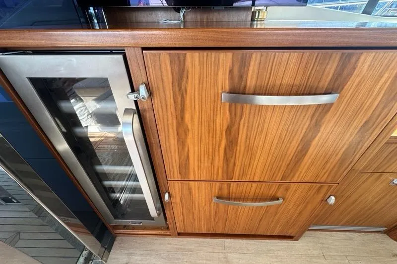 Happy Ours Yacht Photos Pics 2019 Riviera 5400 Sport Yacht interior with wood cabinetry and built-in wine cooler.