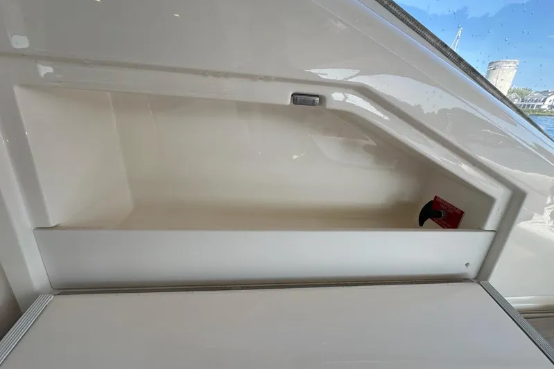 Happy Ours Yacht Photos Pics Storage compartment on a 2019 Riviera 5400 Sport Yacht, featuring sleek white interior design.