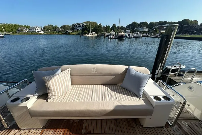 Happy Ours Yacht Photos Pics Luxurious seating on 2019 Riviera 5400 Sport Yacht overlooking serene marina.