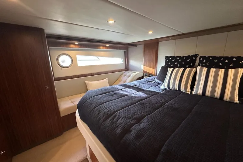 Happy Ours Yacht Photos Pics Luxurious bedroom interior of 2019 Riviera 5400 Sport Yacht with elegant bedding and seating.