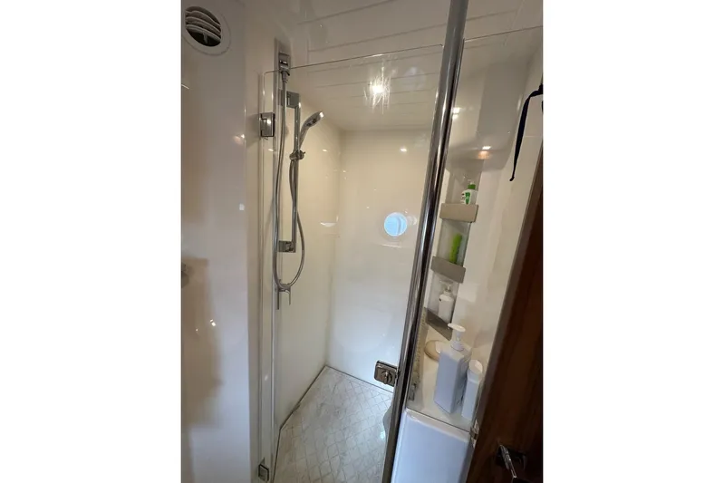Happy Ours Yacht Photos Pics 2019 Riviera 5400 Sport Yacht shower with modern fixtures and storage shelves.