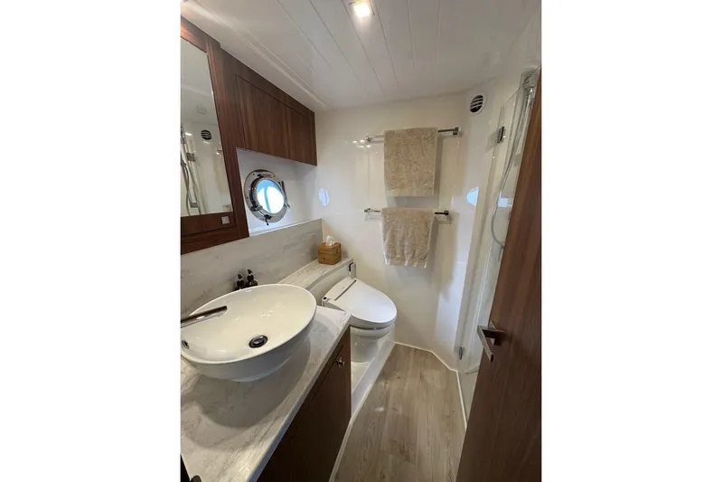 Happy Ours Yacht Photos Pics Luxurious bathroom in 2019 Riviera 5400 Sport Yacht with modern fixtures and porthole window.