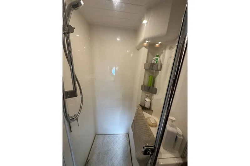 Happy Ours Yacht Photos Pics Shower area in 2019 Riviera 5400 Sport Yacht with modern fixtures and storage shelves.