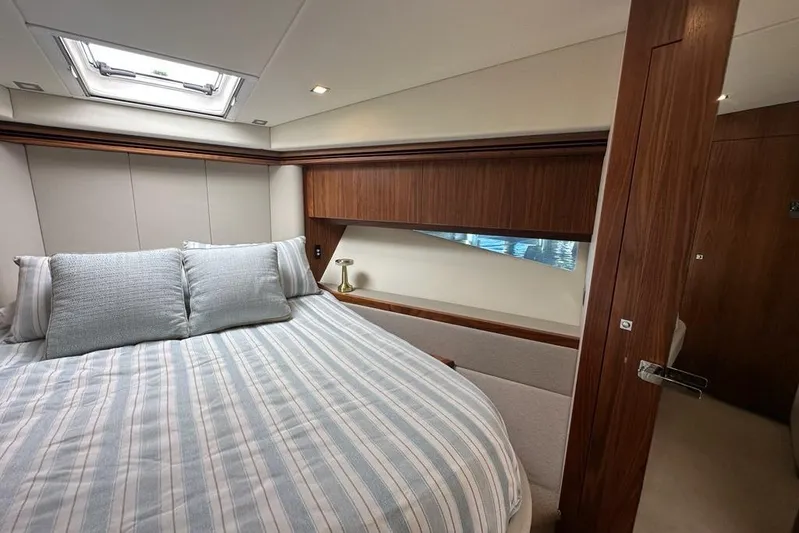 Happy Ours Yacht Photos Pics Luxurious bedroom interior of 2019 Riviera 5400 Sport Yacht with elegant wood finishes.
