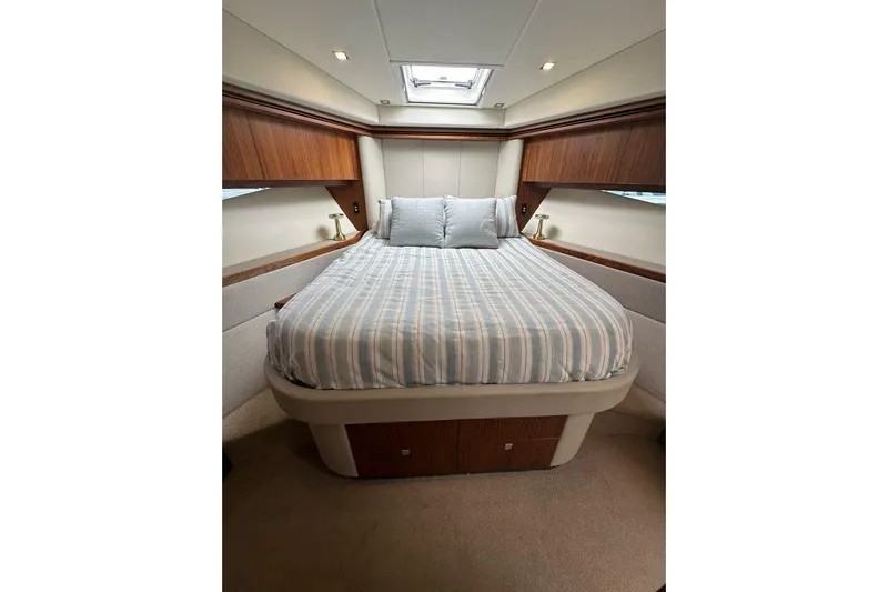Happy Ours Yacht Photos Pics Luxurious bedroom interior of 2019 Riviera 5400 Sport Yacht with striped bedding.