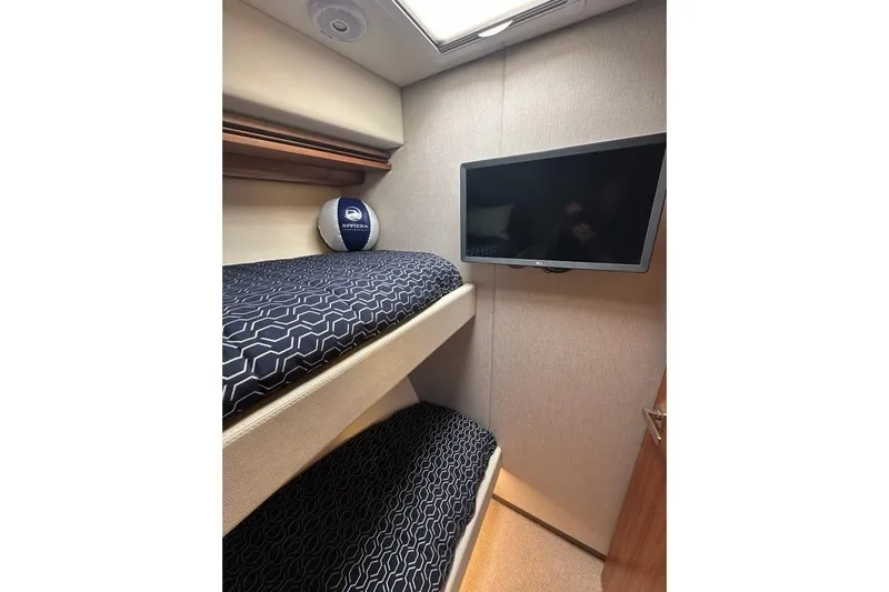 Happy Ours Yacht Photos Pics Interior of 2019 Riviera 5400 Sport Yacht with bunk beds and wall-mounted TV.