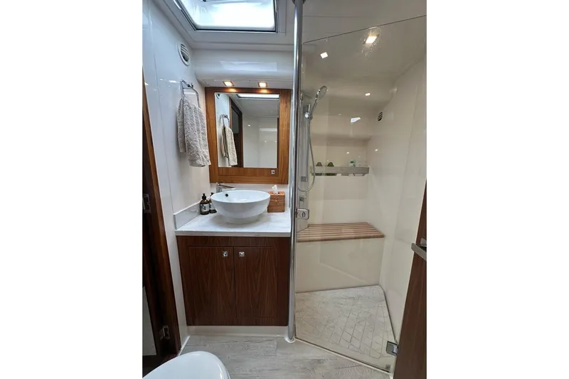 Happy Ours Yacht Photos Pics Luxurious bathroom in 2019 Riviera 5400 Sport Yacht with modern fixtures and glass shower.