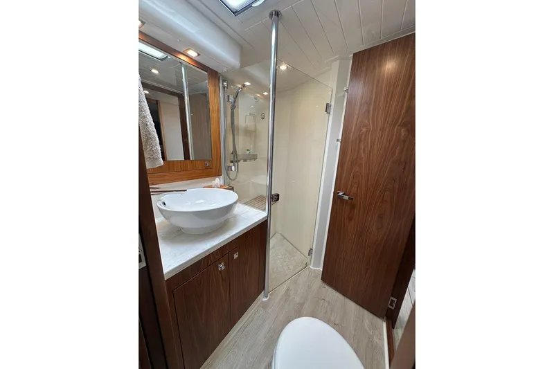 Happy Ours Yacht Photos Pics Luxurious bathroom in 2019 Riviera 5400 Sport Yacht with modern fixtures and wood accents.