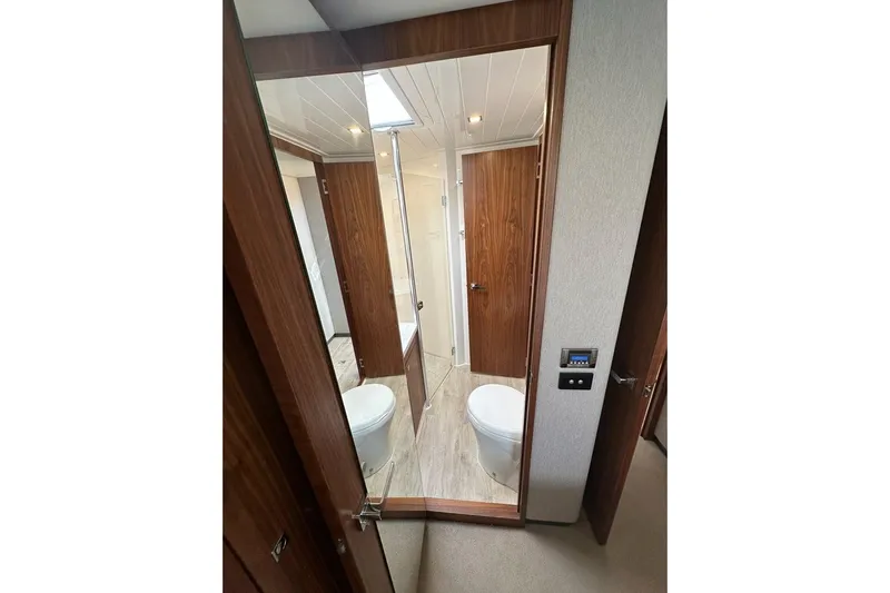 Happy Ours Yacht Photos Pics Bathroom interior of 2019 Riviera 5400 Sport Yacht with wooden accents and modern fixtures.