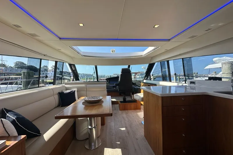 Happy Ours Yacht Photos Pics Luxurious interior of 2019 Riviera 5400 Sport Yacht with modern seating and panoramic windows.