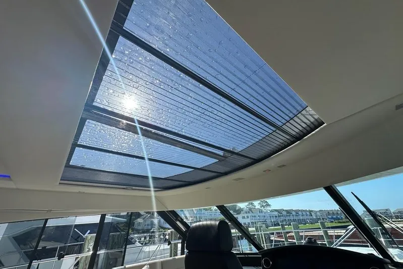 Happy Ours Yacht Photos Pics Sunlit interior of 2019 Riviera 5400 Sport Yacht with panoramic sunroof view.