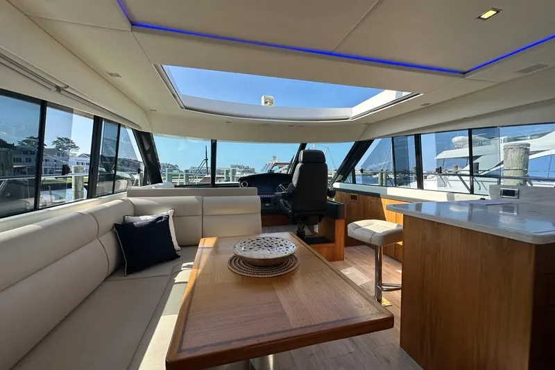 Happy Ours Yacht Photos Pics Luxurious interior of 2019 Riviera 5400 Sport Yacht with panoramic windows and elegant seating.
