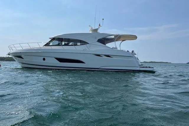 Happy Ours Yacht Photos Pics 2019 Riviera 5400 Sport Yacht cruising on open water under clear skies.