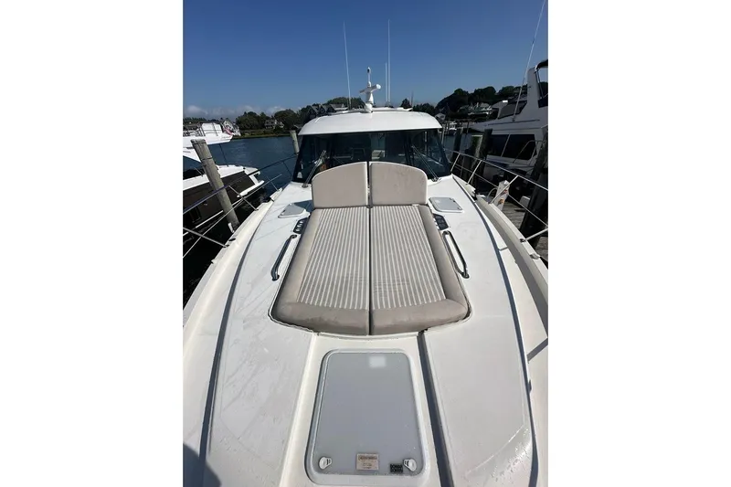 Happy Ours Yacht Photos Pics 2019 Riviera 5400 Sport Yacht with sunbed, docked in a marina under clear skies.