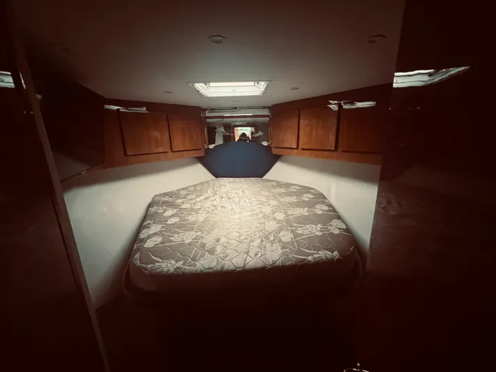 Rock & Roll IV Yacht Photos Pics 2002 Egg Harbor 42 Sport Fish cabin interior with bed and wooden cabinets.