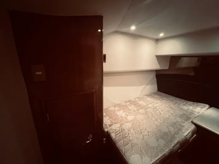 Rock & Roll IV Yacht Photos Pics Interior cabin of a 2002 Egg Harbor 42 Sport Fish boat with bed and wooden door.