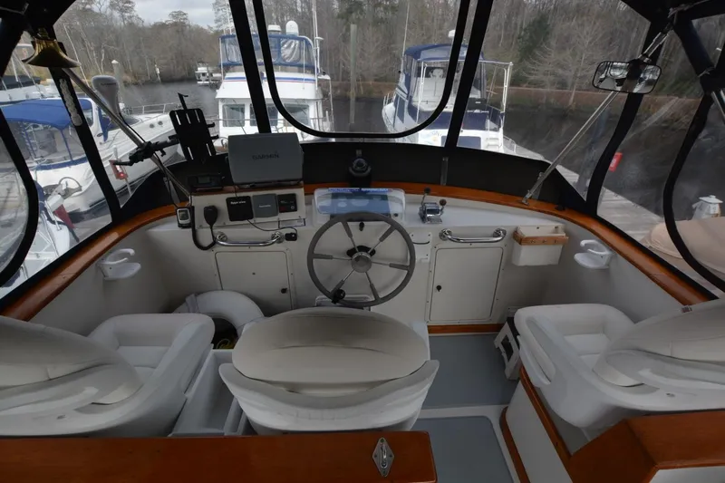 Pau Hana Yacht Photos Pics 1998 Monk Trawler helm with steering wheel, navigation equipment, and comfortable seating.