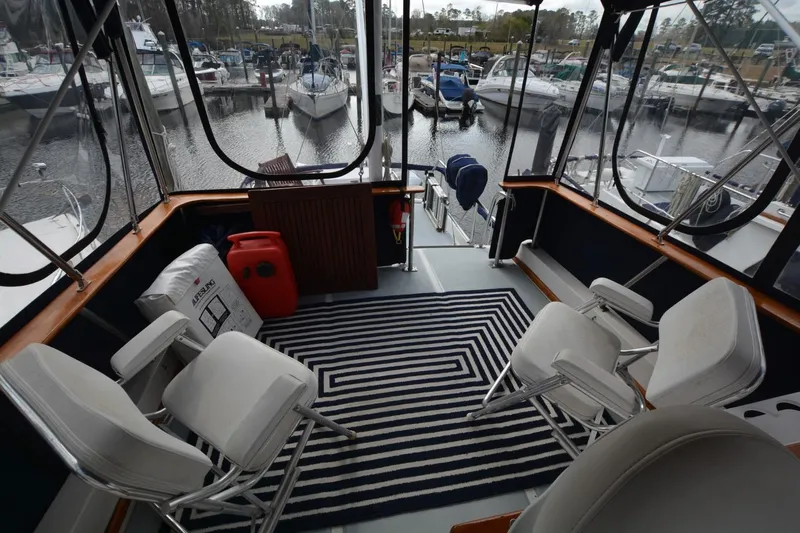 Pau Hana Yacht Photos Pics 1998 Monk Trawler interior with chairs, striped rug, and marina view.