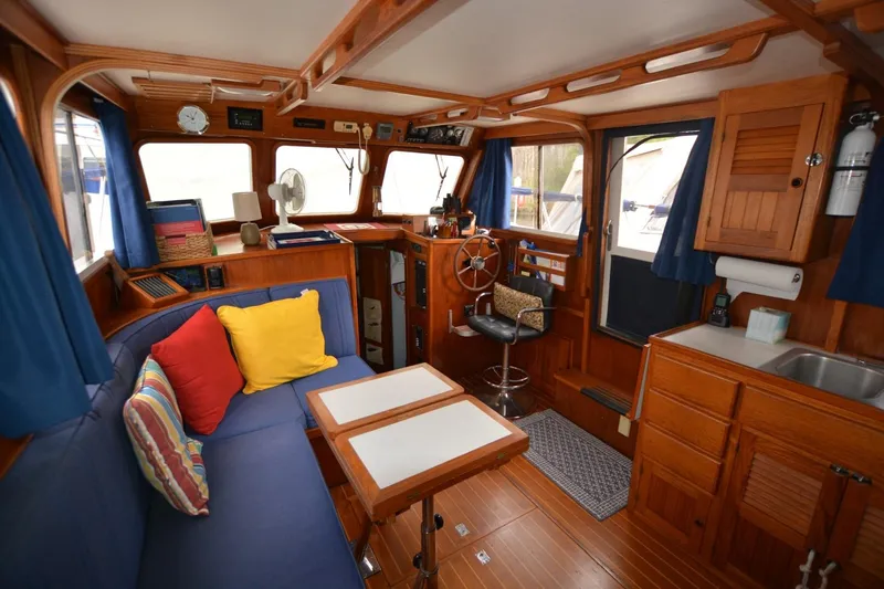 Pau Hana Yacht Photos Pics Cozy 1998 Monk Trawler interior with wooden furnishings, blue seating, and nautical decor.