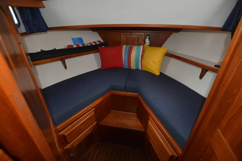 Pau Hana Yacht Photos Pics Cozy cabin interior of 1998 Monk Trawler with colorful cushions and wooden finish.