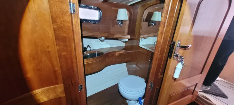 Termo Yacht Photos Pics Wood-paneled bathroom in 2000 Custom Holland Hardtop Cruiser with sink and toilet.