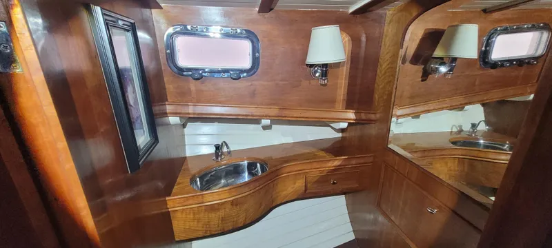 Termo Yacht Photos Pics Luxurious wooden interior of 2000 Custom Holland Hardtop Cruiser with sink and porthole window.