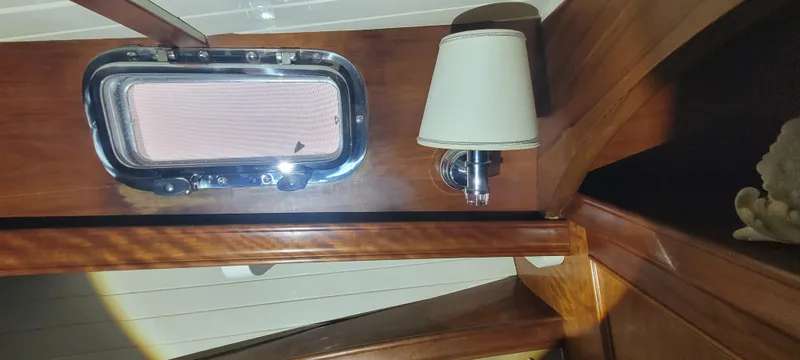 Termo Yacht Photos Pics Interior of 2000 Custom Holland Hardtop Cruiser with wooden paneling and a porthole window.