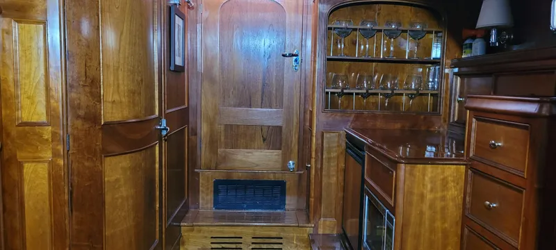 Termo Yacht Photos Pics Luxurious wooden interior of a 2000 Custom Holland Hardtop Cruiser with cabinets and glassware.