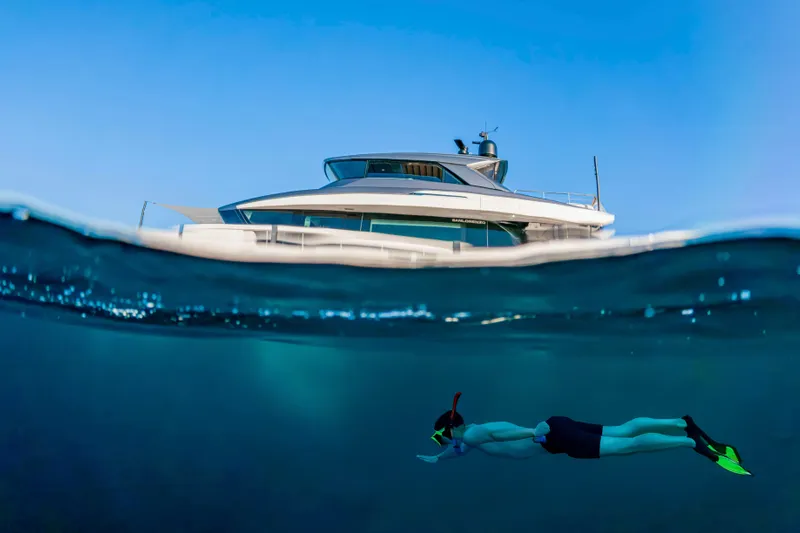 Firefly Yacht Photos Pics Snorkeler swims near 2025 Sanlorenzo SX76 yacht, showcasing luxury and adventure.