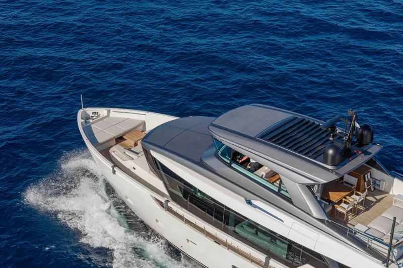 Firefly Yacht Photos Pics Sanlorenzo SX76 2025 yacht cruising on open blue sea, aerial view.