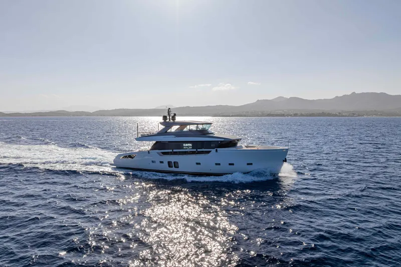 Firefly Yacht Photos Pics 2025 Sanlorenzo SX76 yacht cruising on open sea with scenic mountain backdrop.