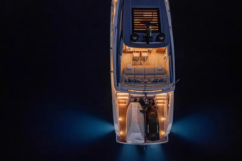 Firefly Yacht Photos Pics Aerial view of illuminated 2025 Sanlorenzo SX76 yacht at night, showcasing luxury design.