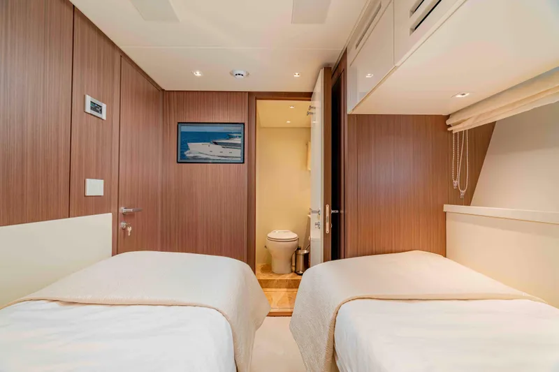 Firefly Yacht Photos Pics Luxurious twin cabin interior on 2025 Sanlorenzo SX76 yacht, featuring modern wood paneling.