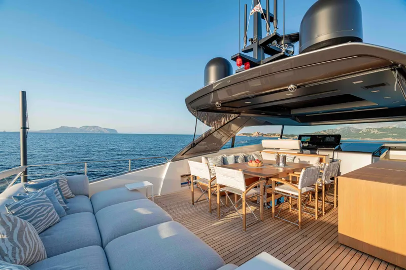 Firefly Yacht Photos Pics Luxurious 2025 Sanlorenzo SX76 yacht deck with elegant seating and dining area, ocean view.