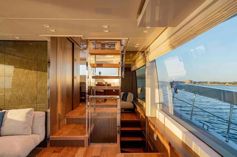 Firefly Yacht Photos Pics Luxurious interior of 2025 Sanlorenzo SX76 yacht with wooden stairs and ocean view.