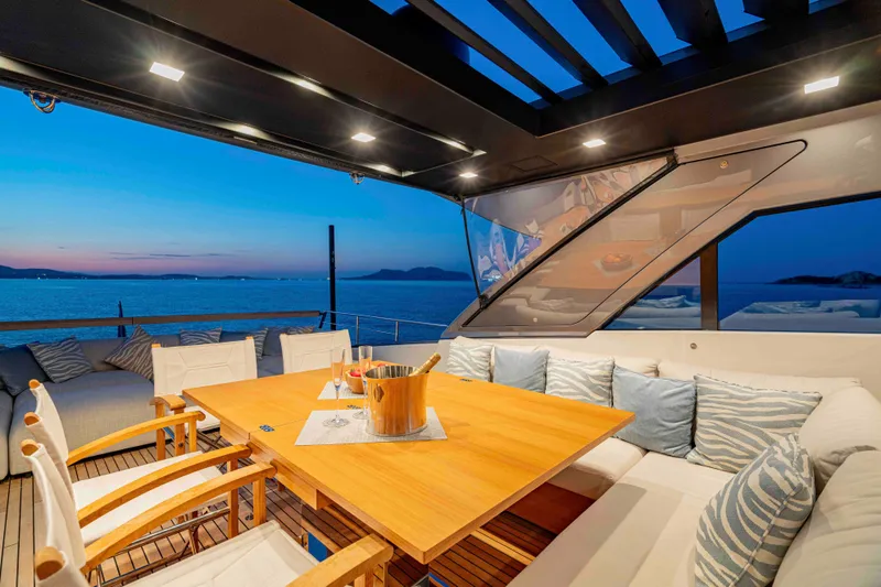 Firefly Yacht Photos Pics Luxurious 2025 Sanlorenzo SX76 yacht deck with elegant seating and ocean view at sunset.