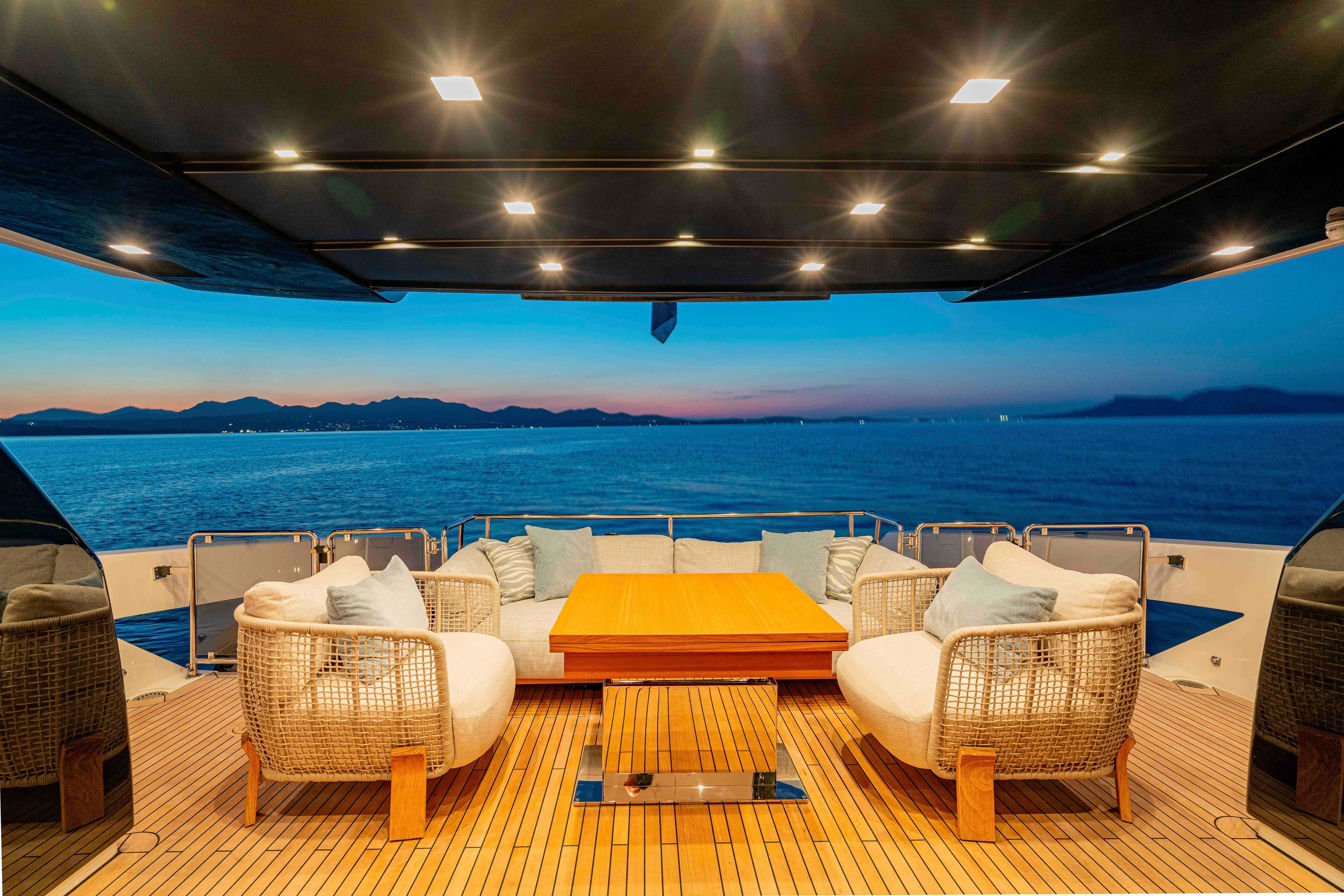 Firefly Yacht Photos Pics Luxurious Sanlorenzo SX76 yacht deck with elegant seating, ocean view, and sunset ambiance, 2025 model.