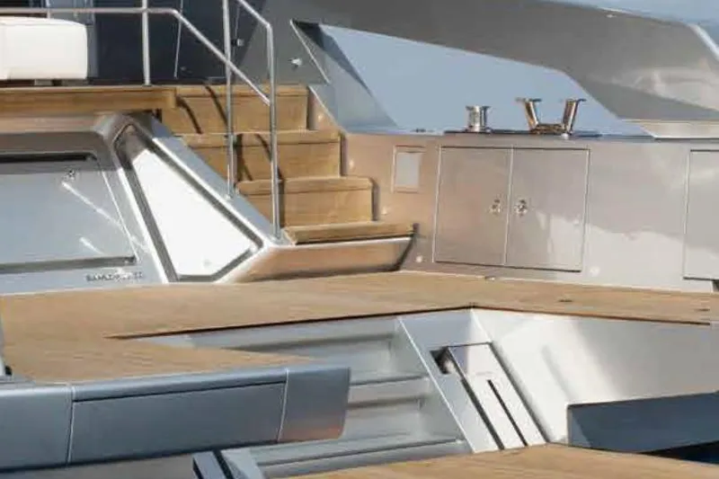 Firefly Yacht Photos Pics 2025 Sanlorenzo SX76 yacht deck with wooden stairs and sleek metal cabinets.