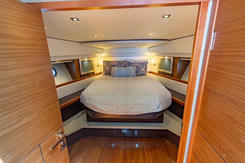 Silver Lining Yacht Photos Pics Luxurious bedroom interior of 2015 Tiara Yachts 44 Coupe with elegant wood finishes.