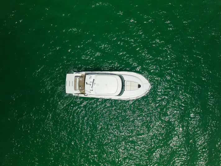 Silver Lining Yacht Photos Pics Overhead view of 2015 Tiara Yachts 44 Coupe on vibrant green water.