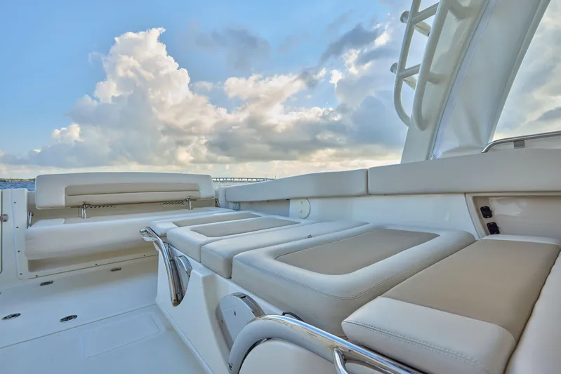 Hitm Yacht Photos Pics 2016 Boston Whaler 320 Vantage boat interior with cushioned seating and cloudy sky backdrop.