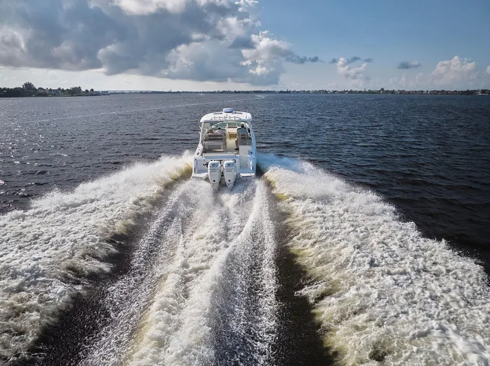 Hitm Yacht Photos Pics 2016 Boston Whaler 320 Vantage cruising on open water, leaving a wake behind.