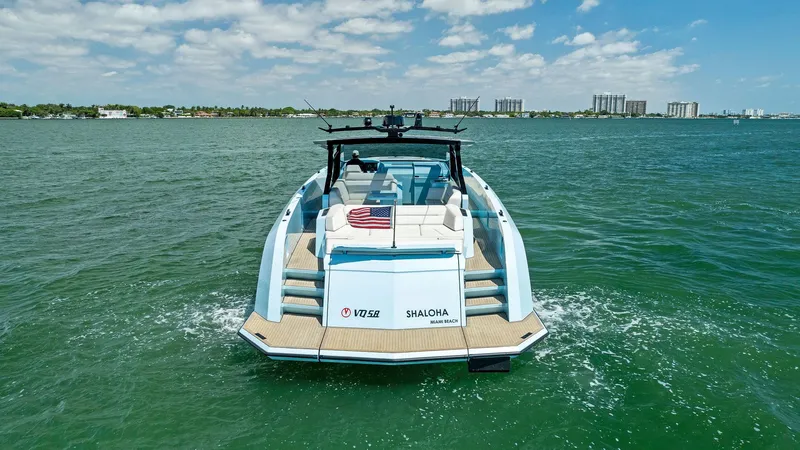 Shaloha Yacht Photos Pics 2022 Vanquish Yachts VQ58 cruising on open water with city skyline in background.