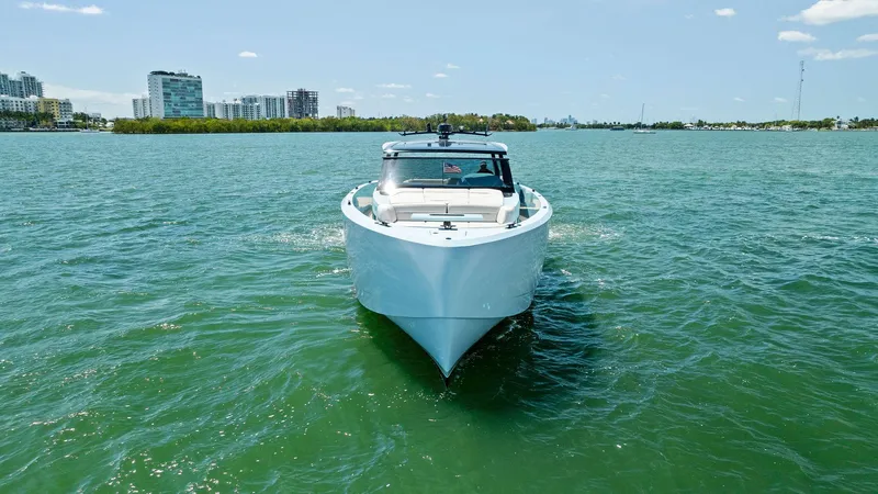 Shaloha Yacht Photos Pics 2022 Vanquish Yachts VQ58 cruising on a sunny day in a coastal city.